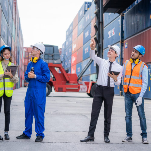 Engineer team and Businessman planning the transportation of goo Engineer team and Businessman planning the transportation of goods for import or export in the container yard.