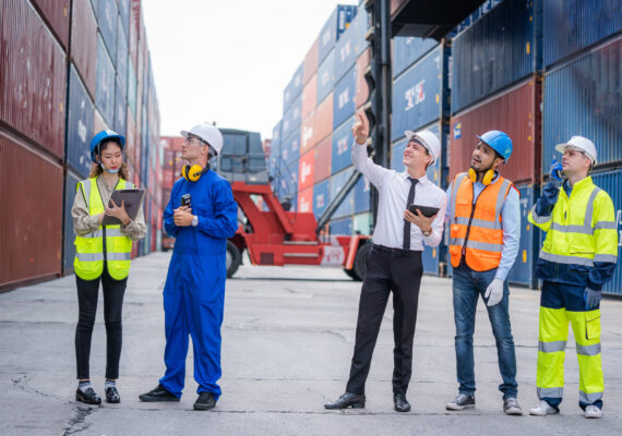 Engineer team and Businessman planning the transportation of goo Engineer team and Businessman planning the transportation of goods for import or export in the container yard.